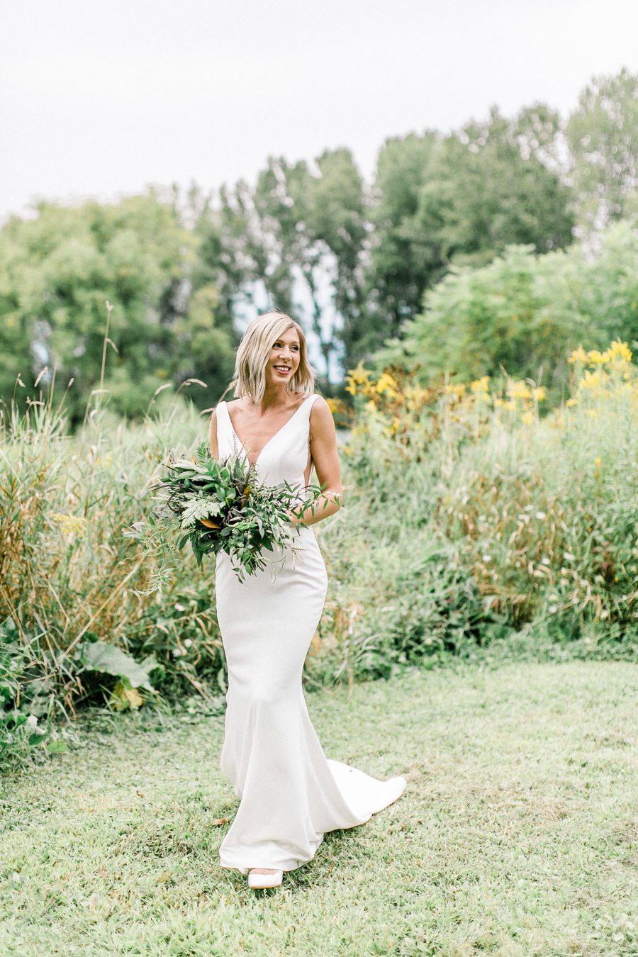 modern greenhouse wedding photos, carly mccray photography, lake geneva wedding photographer, madison wedding photographers, modern greenery wedding, modern wisconsin greenhouse wedding, modern greenery wedding, sleek wedding dress, greenery boutonnieres, black taper candles, green florals, modern greens