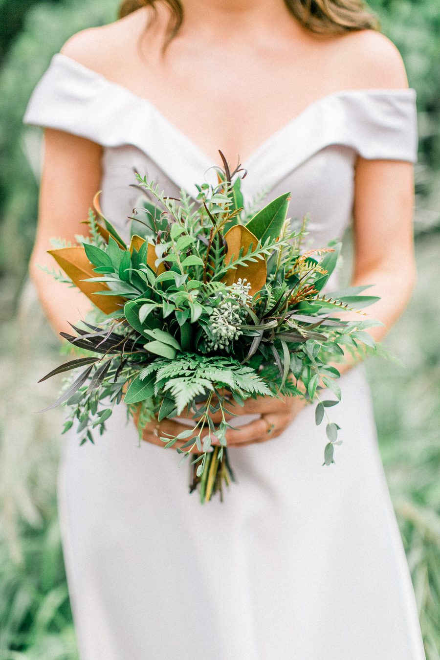 modern greenhouse wedding photos, carly mccray photography, lake geneva wedding photographer, madison wedding photographers, modern greenery wedding, modern wisconsin greenhouse wedding, modern greenery wedding, sleek wedding dress, greenery boutonnieres, black taper candles, green florals, modern greens