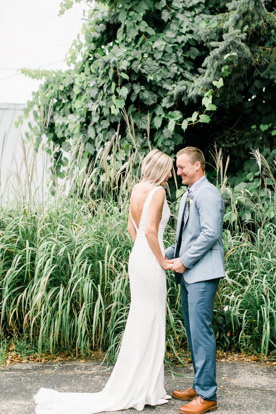 modern greenhouse wedding photos, carly mccray photography, lake geneva wedding photographer, madison wedding photographers, modern greenery wedding, modern wisconsin greenhouse wedding, modern greenery wedding, sleek wedding dress, greenery boutonnieres, black taper candles, green florals, modern greens