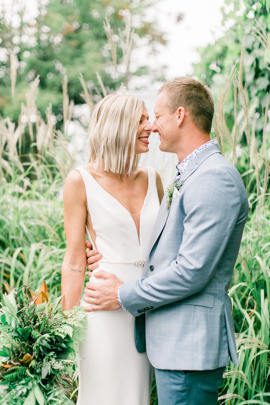 modern greenhouse wedding photos, carly mccray photography, lake geneva wedding photographer, madison wedding photographers, modern greenery wedding, modern wisconsin greenhouse wedding, modern greenery wedding, sleek wedding dress, greenery boutonnieres, black taper candles, green florals, modern greens