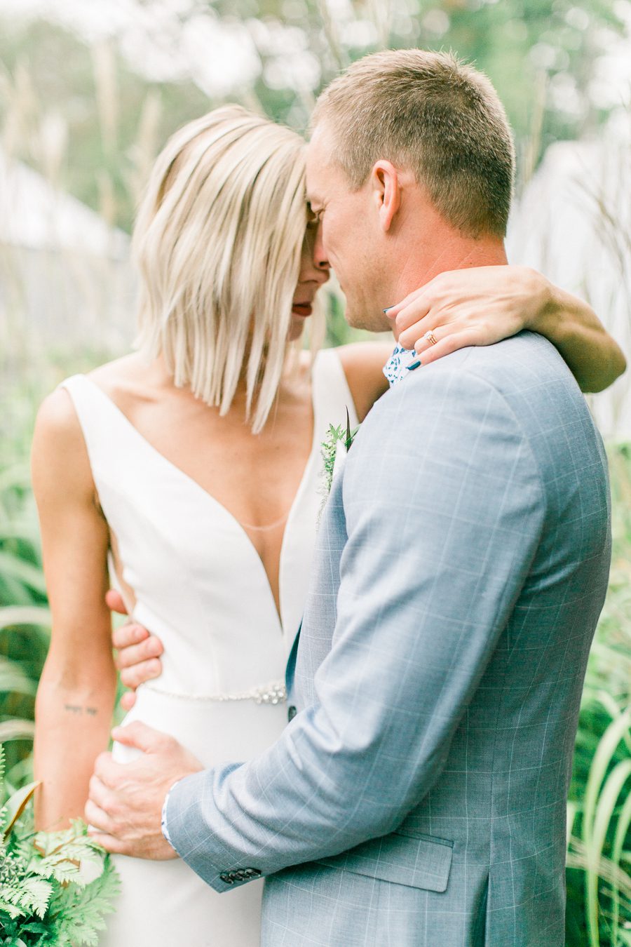 modern greenhouse wedding photos, carly mccray photography, lake geneva wedding photographer, madison wedding photographers, modern greenery wedding, modern wisconsin greenhouse wedding, modern greenery wedding, sleek wedding dress, greenery boutonnieres, black taper candles, green florals, modern greens