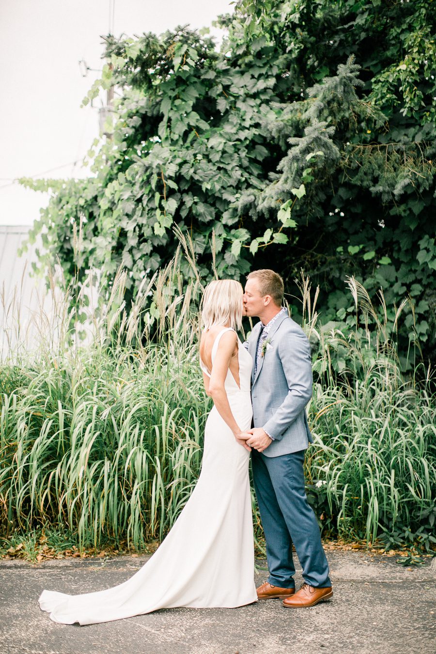 modern greenhouse wedding photos, carly mccray photography, lake geneva wedding photographer, madison wedding photographers, modern greenery wedding, modern wisconsin greenhouse wedding, modern greenery wedding, sleek wedding dress, greenery boutonnieres, black taper candles, green florals, modern greens