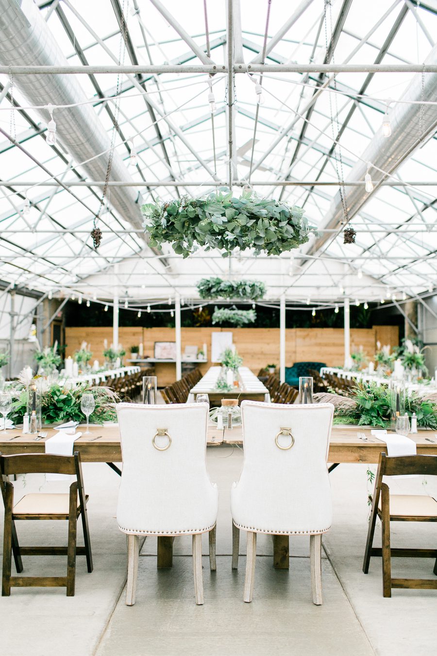 modern greenhouse wedding photos, carly mccray photography, lake geneva wedding photographer, madison wedding photographers, modern greenery wedding, modern wisconsin greenhouse wedding, modern greenery wedding, sleek wedding dress, greenery boutonnieres, black taper candles, green florals, modern greens