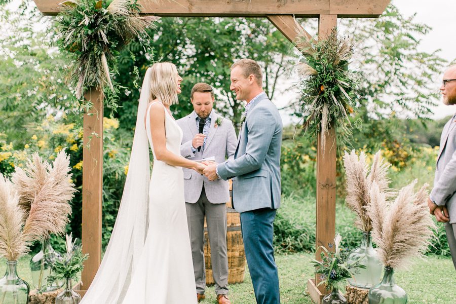 modern greenhouse wedding photos, carly mccray photography, lake geneva wedding photographer, madison wedding photographers, modern greenery wedding, modern wisconsin greenhouse wedding, modern greenery wedding, sleek wedding dress, greenery boutonnieres, black taper candles, green florals, modern greens