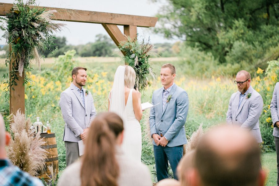 modern greenhouse wedding photos, carly mccray photography, lake geneva wedding photographer, madison wedding photographers, modern greenery wedding, modern wisconsin greenhouse wedding, modern greenery wedding, sleek wedding dress, greenery boutonnieres, black taper candles, green florals, modern greens