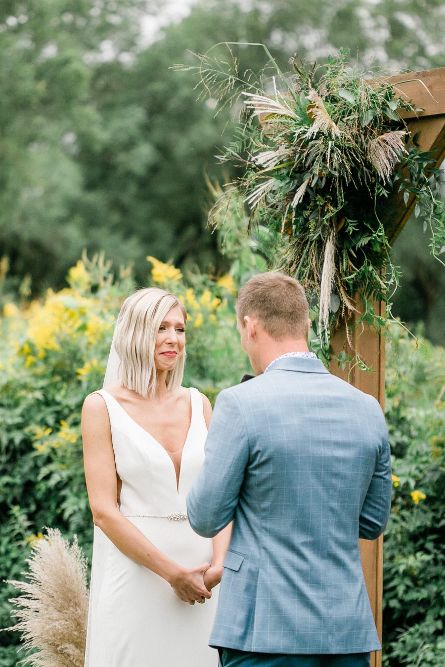 modern greenhouse wedding photos, carly mccray photography, lake geneva wedding photographer, madison wedding photographers, modern greenery wedding, modern wisconsin greenhouse wedding, modern greenery wedding, sleek wedding dress, greenery boutonnieres, black taper candles, green florals, modern greens