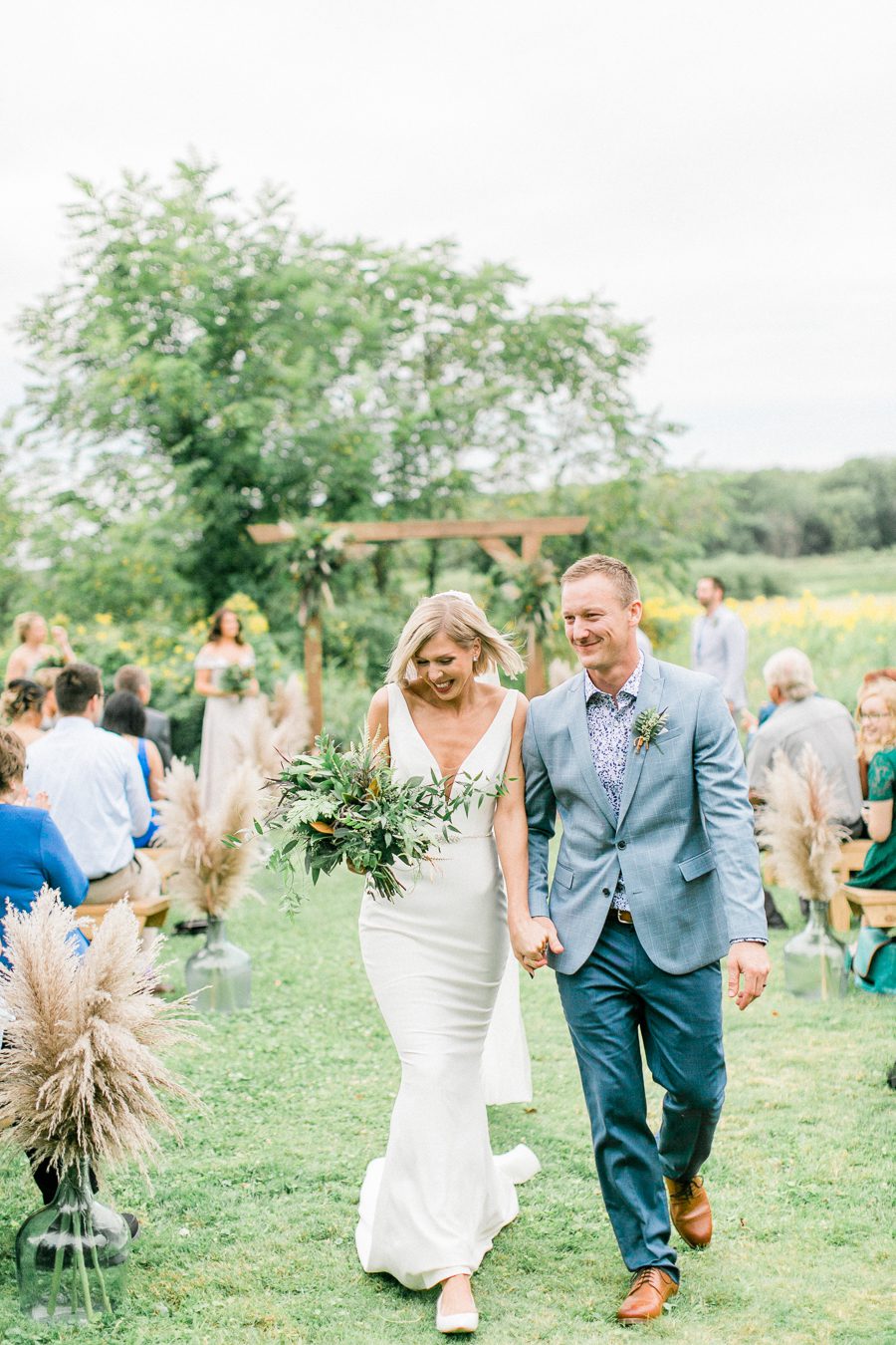 modern greenhouse wedding photos, carly mccray photography, lake geneva wedding photographer, madison wedding photographers, modern greenery wedding, modern wisconsin greenhouse wedding, modern greenery wedding, sleek wedding dress, greenery boutonnieres, black taper candles, green florals, modern greens