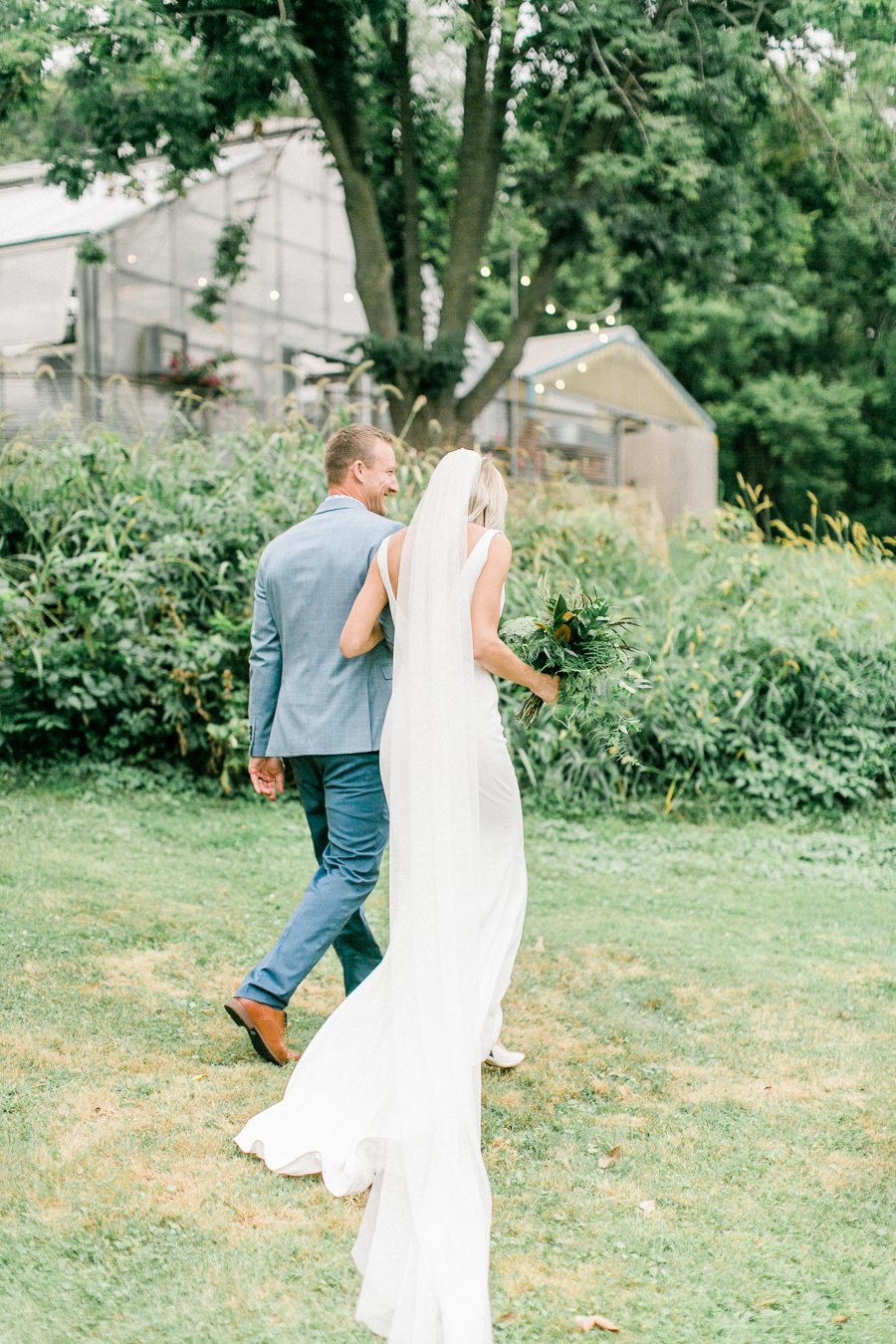 modern greenhouse wedding photos, carly mccray photography, lake geneva wedding photographer, madison wedding photographers, modern greenery wedding, modern wisconsin greenhouse wedding, modern greenery wedding, sleek wedding dress, greenery boutonnieres, black taper candles, green florals, modern greens