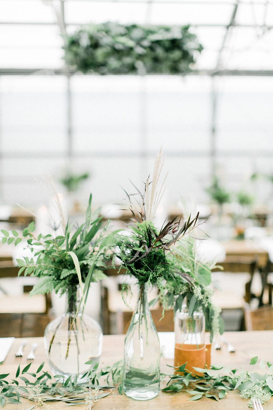 modern greenhouse wedding photos, carly mccray photography, lake geneva wedding photographer, madison wedding photographers, modern greenery wedding, modern wisconsin greenhouse wedding, modern greenery wedding, sleek wedding dress, greenery boutonnieres, black taper candles, green florals, modern greens