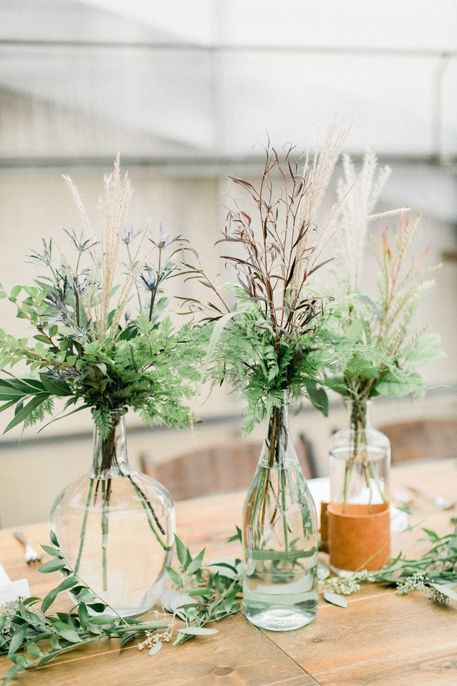 modern greenhouse wedding photos, carly mccray photography, lake geneva wedding photographer, madison wedding photographers, modern greenery wedding, modern wisconsin greenhouse wedding, modern greenery wedding, sleek wedding dress, greenery boutonnieres, black taper candles, green florals, modern greens