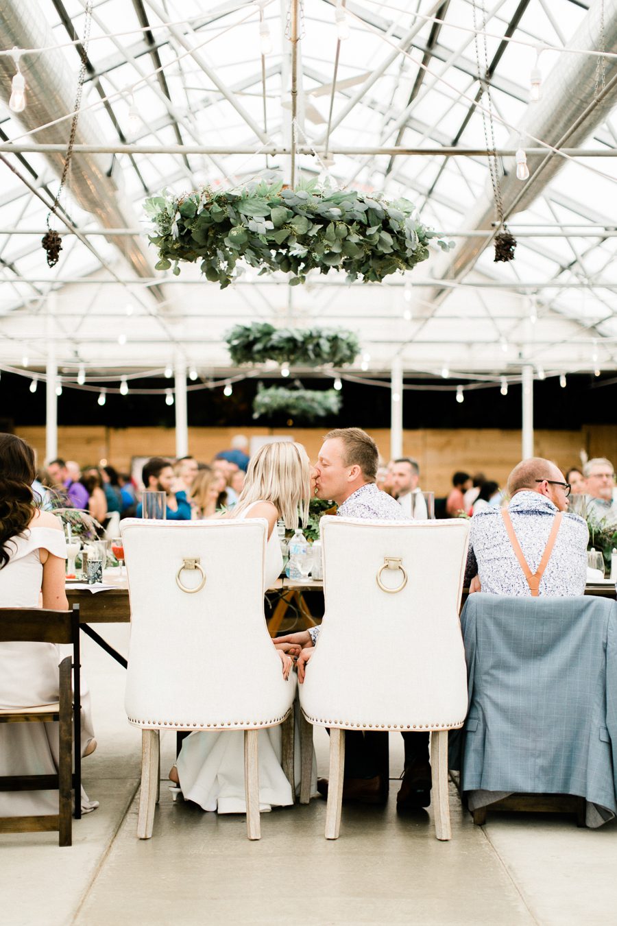 modern greenhouse wedding photos, carly mccray photography, lake geneva wedding photographer, madison wedding photographers, modern greenery wedding, modern wisconsin greenhouse wedding, modern greenery wedding, sleek wedding dress, greenery boutonnieres, black taper candles, green florals, modern greens