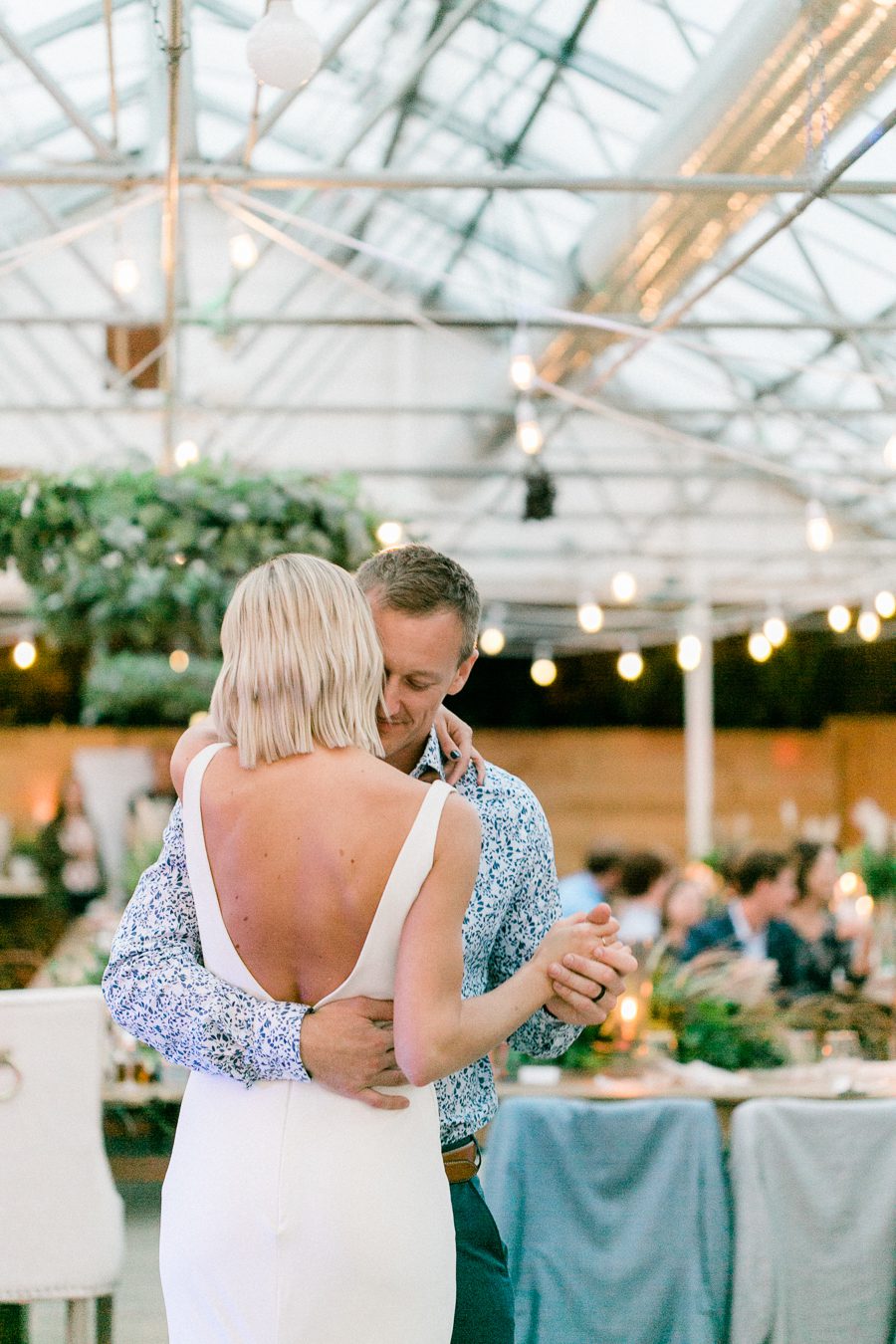 modern greenhouse wedding photos, carly mccray photography, lake geneva wedding photographer, madison wedding photographers, modern greenery wedding, modern wisconsin greenhouse wedding, modern greenery wedding, sleek wedding dress, greenery boutonnieres, black taper candles, green florals, modern greens